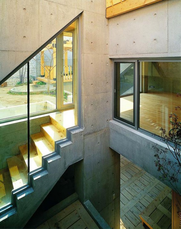 Great Combination of Wood and Concrete in a Courtyard House Design - Glass Decoration for Staircase