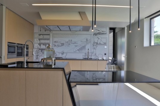 Kitchen Incorporating Comic Mural Covering the Center Wall By A Cero Architects